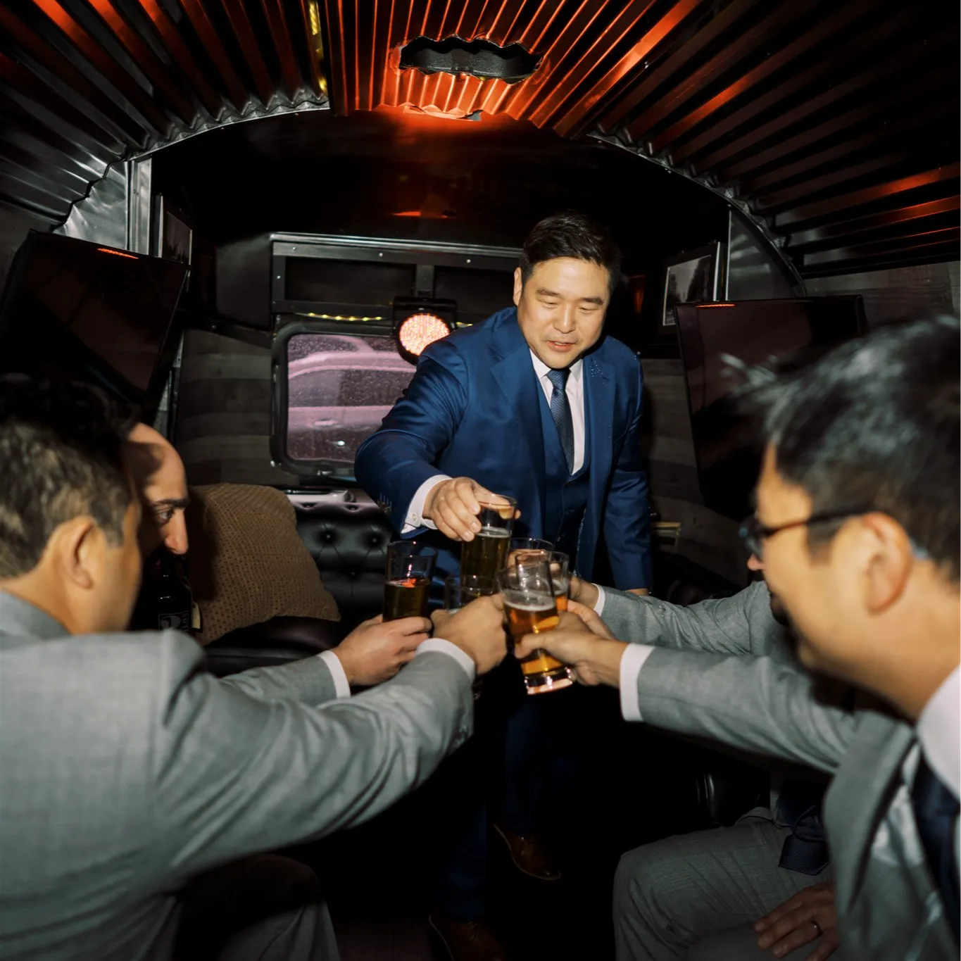 Groom prepares for the wedding in the Airstream Cigar Lounge with groomsmen