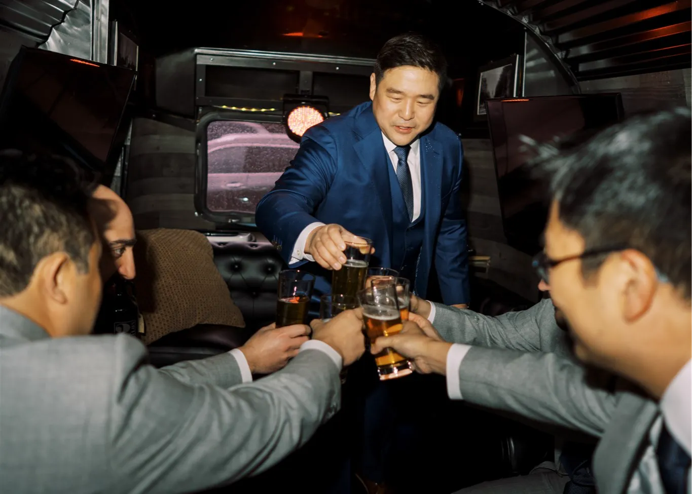 Groom and groomsmen toast inside the Airstream Cigar Lounge